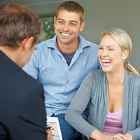 Man and woman talking to a man in a suit.